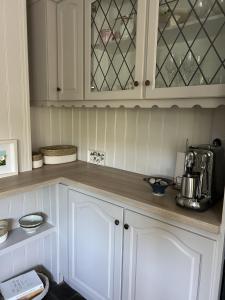 cocina con armarios blancos y encimera en Moyleroe Bridge, en Mullingar