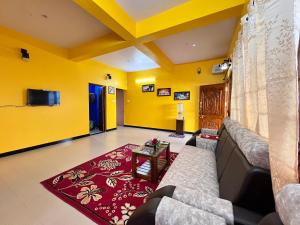 - un salon avec des murs jaunes et un canapé dans l'établissement Golden View Cottage Ooty, à Ooty