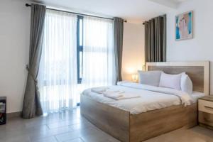 a bedroom with a large bed and a large window at Central 2 Bed Apartment in Cantonments +78 photos
