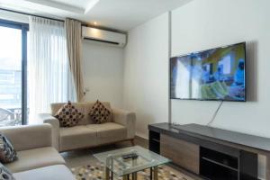 a living room with a couch and a flat screen tv at Central 2 Bed Apartment in Cantonments