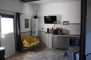 uma cozinha com uma cadeira amarela e um micro-ondas em L'instant Détente 34 em Saint-Aunès