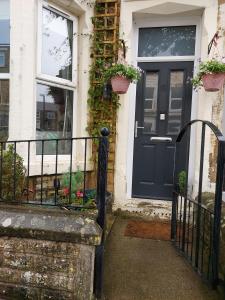 una puerta azul en una casa con plantas en Morecambe Seaside Room, en Heysham