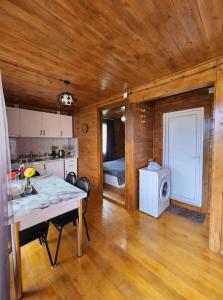 a kitchen and living room with a table and a refrigerator at Racha Nanida in Agara