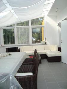 a dining room with a table and chairs and windows at Ferienhaus mit Wintergarten am See (Angelparadies) in Parey
