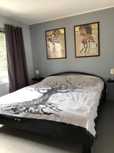 um quarto com uma cama com duas fotografias na parede em Ferienhaus mit Wintergarten am See (Angelparadies) em Parey