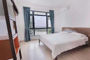 ein Schlafzimmer mit einem Bett und einem großen Fenster in der Unterkunft 29 FOREST CITY ataraxia park homestay D in Gelang Patah