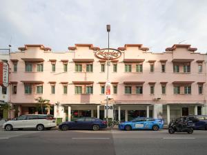 een groot roze gebouw met auto's geparkeerd voor het bij Amrise Hotel, Check in at 10PM, Check out at 9AM in Singapore