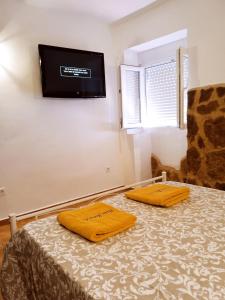 - une chambre avec un lit et 2 serviettes jaunes dans l'établissement Casa Jobacho, à Algar