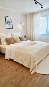 duże białe łóżko w sypialni z drewnianą podłogą w obiekcie Luxuriös & Sehr Zentral in Wuppertal w mieście Wuppertal