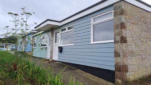 una casa azul con ventanas blancas en el lateral de ella en Chalet 80, en Sandown