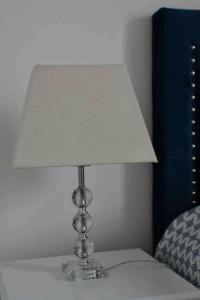 a lamp sitting on a table next to a bed at Studio Le Mansart au pied du Château Insead in Fontainebleau