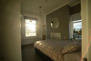 1 dormitorio con cama, espejo y ventana en Georgian Gem Free Parking &Views en Bath