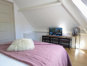 a bedroom with a bed with a pink blanket at Stylish Guesthouse with 2 Free E-bikes - near Breda! in Etten-Leur
