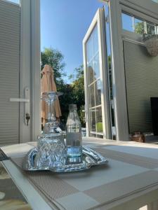 a glass bottle on a glass tray on a table at Studio with a hot tub and garden in East Barnet