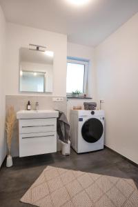 a bathroom with a washing machine and a sink at VOYAGE Stadtoase am Fluss I Zentral I freier Parkplatz I Wifi I Netflix I Aufzug in Kempten