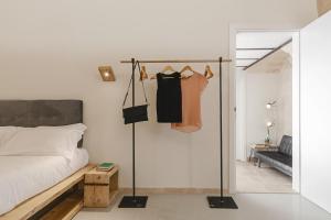 ein Schlafzimmer mit einem Bett und einem Kleiderschrank mit Kleidung in der Unterkunft Hydria Rooms in Matera