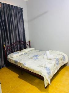 een bed in een kamer met een zwart gordijn bij Lala Homestay Sandakan in Sandakan