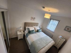 a bedroom with a bed with pillows and a window at 10 Ladyknowe court in Moffat