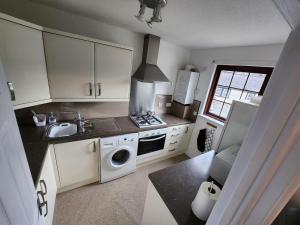 a kitchen with a sink and a stove top oven at 10 Ladyknowe court in Moffat