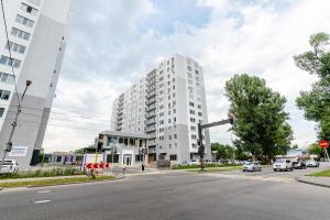 un grand bâtiment blanc dans une rue de la ville avec un feu de circulation dans l'établissement Очаровательная квартира в ЖК Атлант, à Almaty