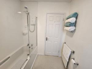 ein Bad mit einer Dusche, einem WC und Handtüchern in der Unterkunft 10 Ladyknowe court in Moffat