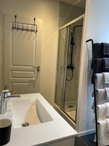 een witte badkamer met een wastafel en een douche bij Casa Luna, Votre Maison Familiale avec son jardin privé en Plein Cœur de Ville in Bourges