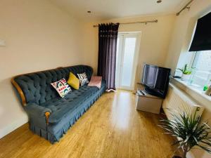 a living room with a couch and a tv at Cosy ground floor apartment in Huntingdon