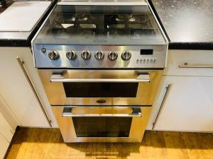 a stainless steel oven in a kitchen at Cosy ground floor apartment in Huntingdon