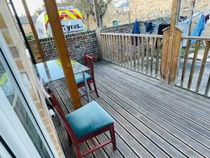 a porch with two chairs and a table on a deck at Cosy ground floor apartment in Huntingdon