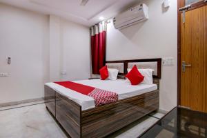 a bedroom with a bed with red pillows at Flagship Shyam Villa in New Delhi