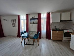 - une cuisine avec une table en verre et des chaises dans la chambre dans l'établissement Grand Appartement cosy et lumineux, à Mons