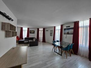 ein Wohnzimmer mit einem Tisch und einem Sofa in der Unterkunft Grand Appartement cosy et lumineux in Mons