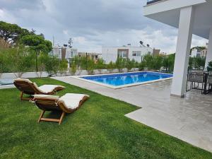 a yard with chairs and a swimming pool at Beach House by the Lagoon - Piscina Privada in Casal do Narcizo
