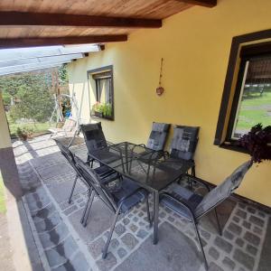 une table et des chaises assises sur une terrasse dans l'établissement Na Kopci 84, à Staré Křečany