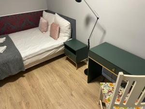 a bedroom with a bed and a desk and a chair at Apartment Chorzow Center in Chorzów