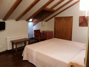 1 dormitorio con 1 cama, mesa y sillas en Hotel Aragüells, en Benasque