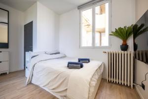 a bedroom with a bed with two blue towels on it at Renovated Studio walking distance to Paris in Montrouge