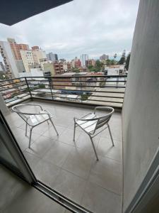 two chairs on a balcony with a view of a city at Apart Moderno a Estrenar Barrio Sur in San Miguel de Tucumán