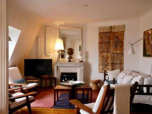 uma sala de estar com um sofá e uma lareira em Superbe appartement de 120m2 en plein Paris em Paris