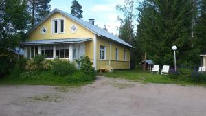una casa amarilla con una entrada delante de ella en Miekkala Lomatalo en Ilottula