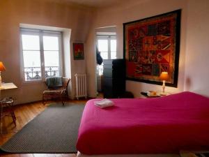 um quarto com uma grande cama vermelha e uma janela em Superbe appartement de 120m2 en plein Paris em Paris