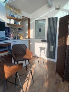 a kitchen with two chairs and a table and a counter at Studio with a hot tub and garden in East Barnet