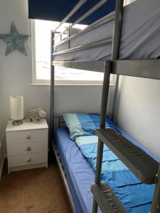 a bedroom with a bunk bed with a blue bed at Chalet 80 in Sandown