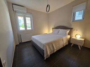 um quarto com uma cama grande e 2 janelas em Viggas Relaxation Nafpaktos em Antirrio