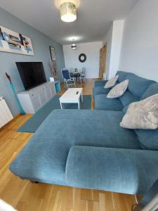 a living room with a blue couch and a television at El Silencio de Galadhrim in Ponferrada