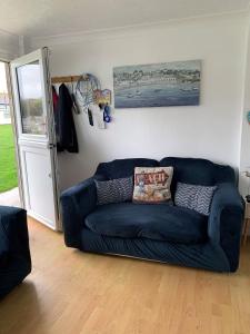 niebieską kanapę siedzącą w salonie w obiekcie Chalet 80 w mieście Sandown