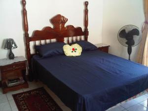 a bedroom with a blue bed with a pillow on it at Melrose Place in Montego Bay