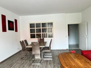 een woonkamer met een tafel en stoelen en een bank bij Wiehengebirgs Fernblick App 3 in Bad Essen