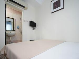 a white room with a bed and a sink at Amrise Hotel, Check in at 10PM, Check out at 9AM in Singapore