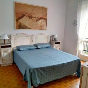 um quarto com uma cama com um quadro na parede em Appartamento Giglio em Stropino